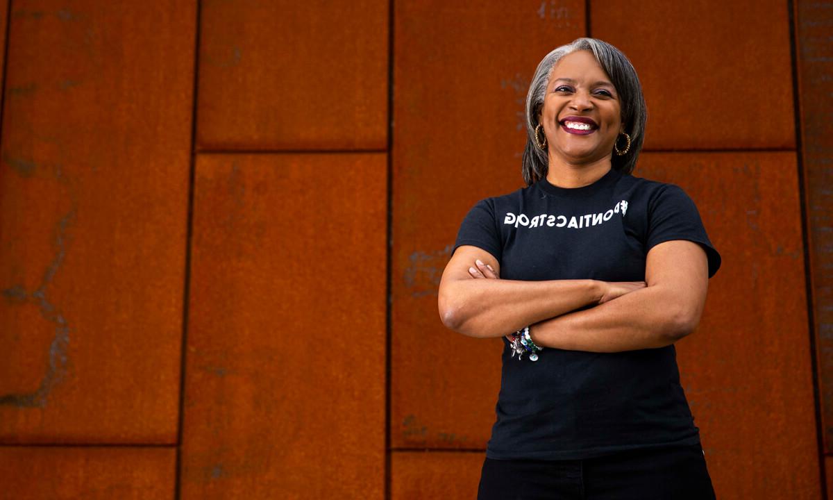 Woman standing in front of a metal wall with her arms crossed